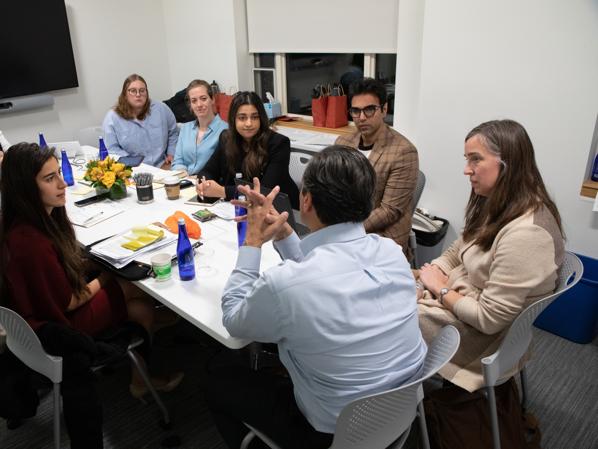 Affiliated students and fellows talk around a table