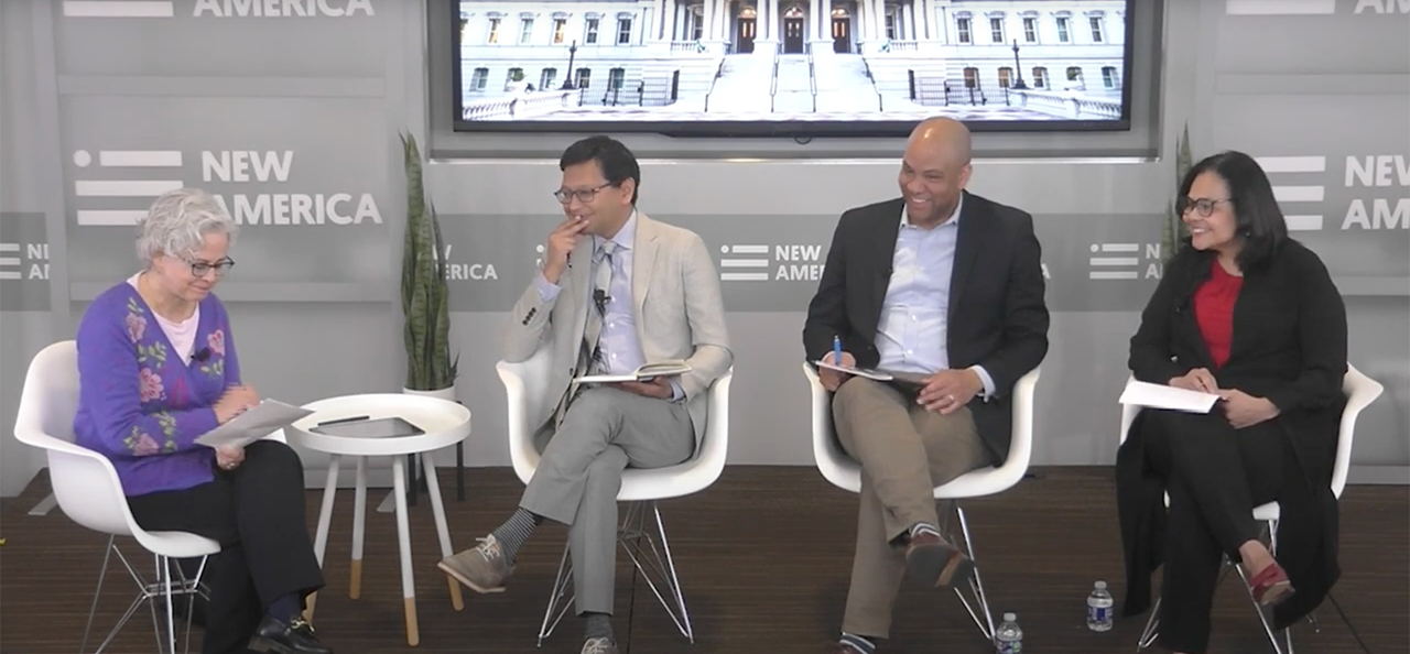 four person panel, all seated in white chairs