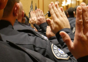 sheriffs in room with hands raised