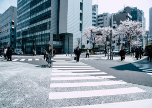 people walking on a crosswalk in a city