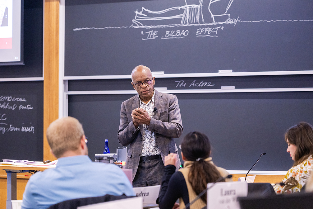 Professor standing in front of blackboard, teaching students