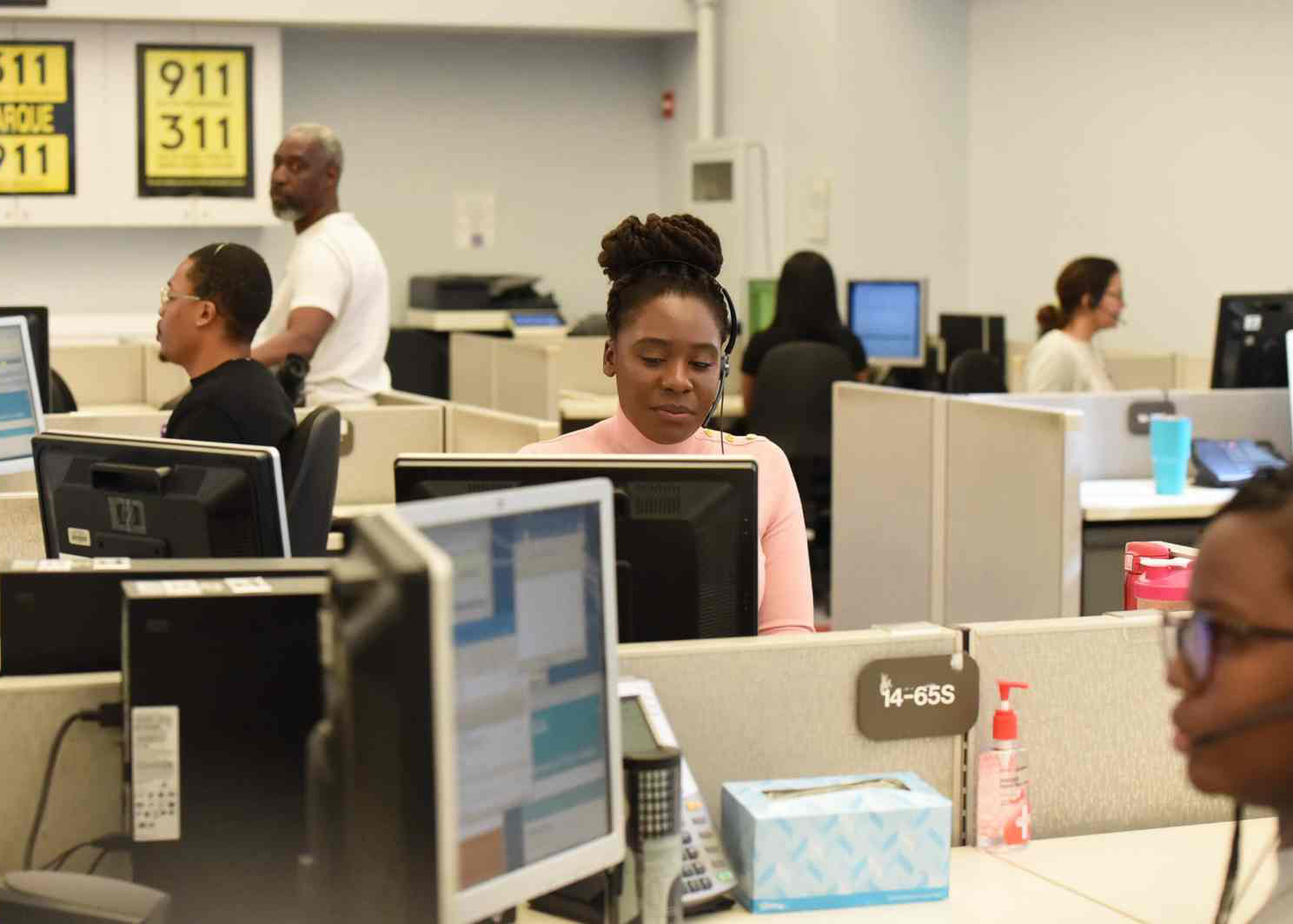 people in a meeting around a table with laptops