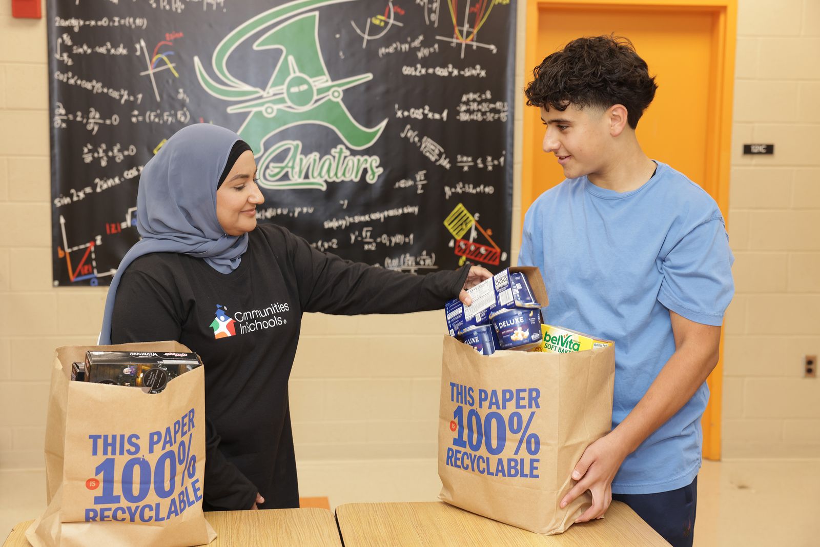 woman and young man with paper bags of groceries