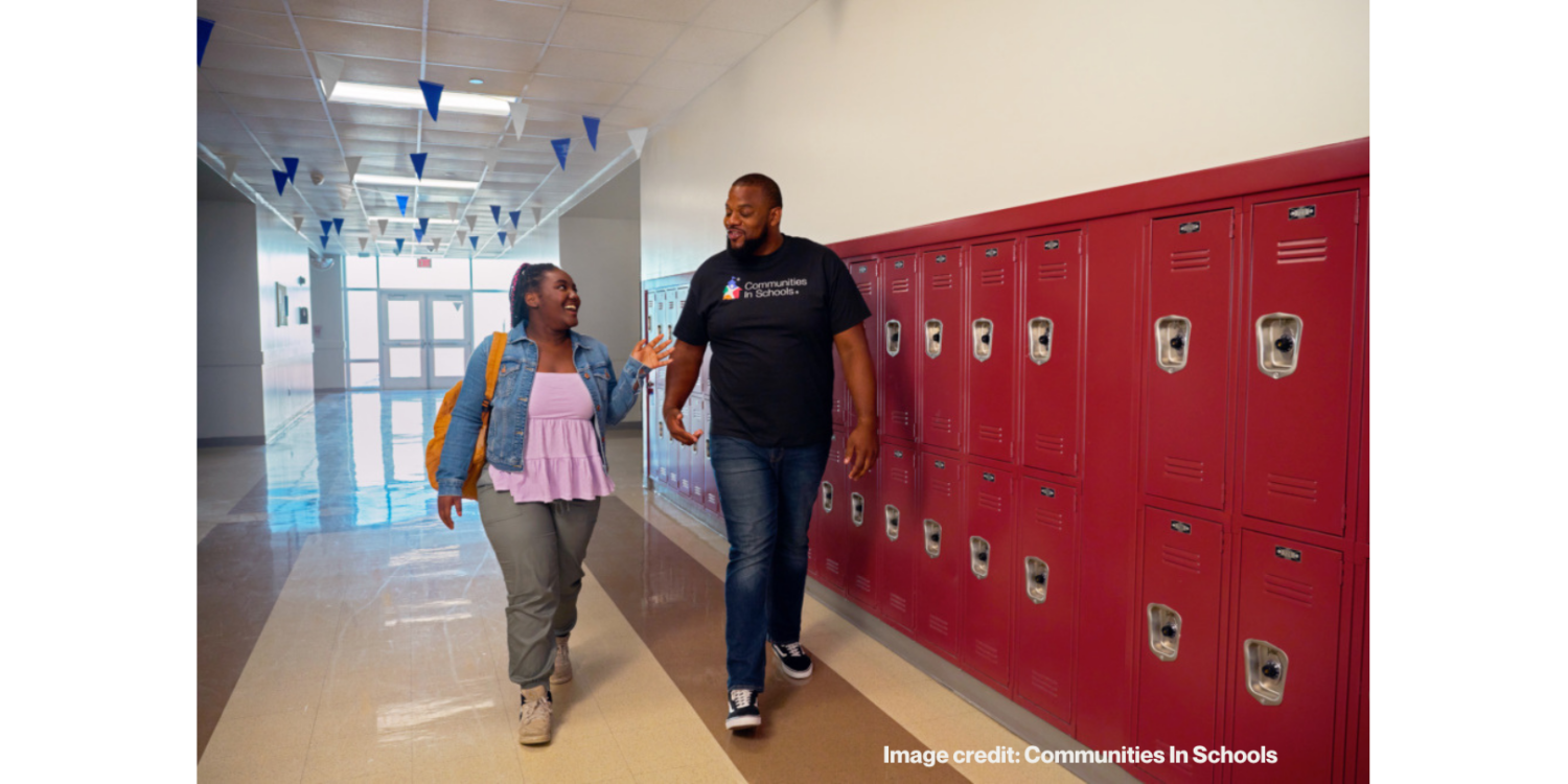 two people walking down the hall in a school